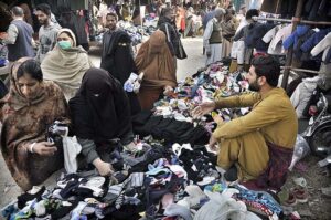 A couple busy in selecting and purchasing second hand warm clothes displayed by vendor at I-9 Weekly Bazaar in Federal Capital.