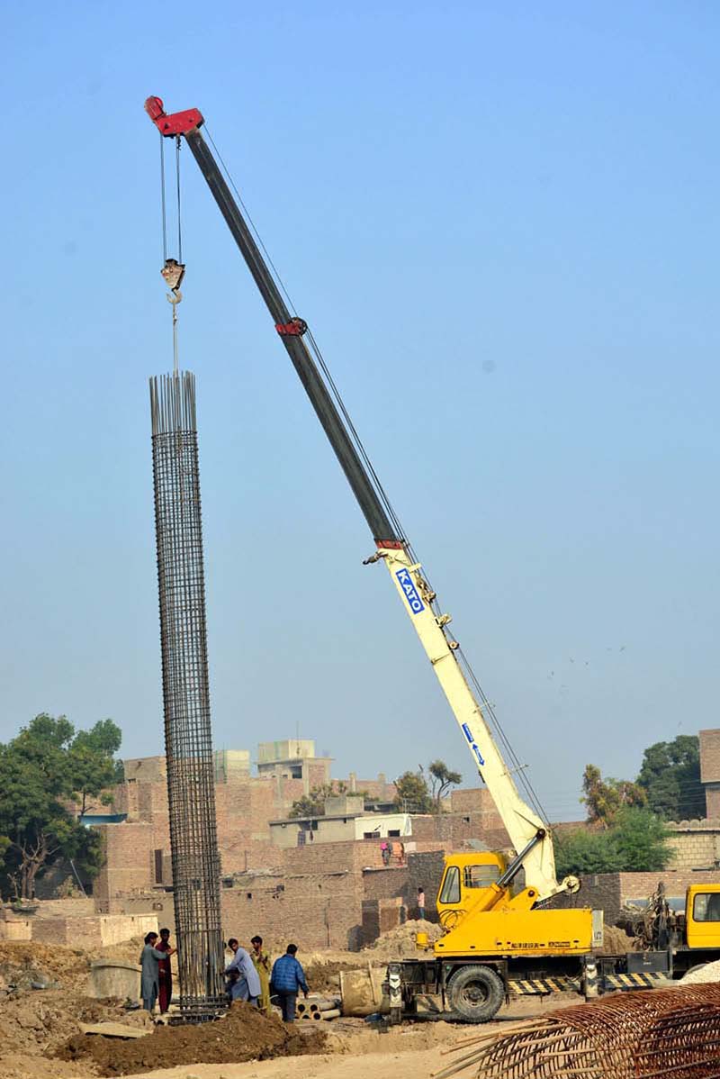 Labourers busy in construction work of water filtration plant with the help of crane at Latifabad