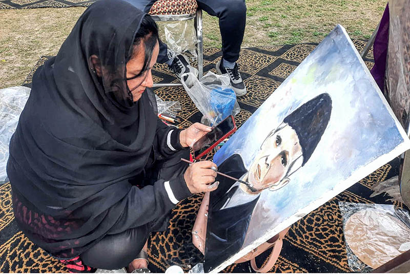 Participant giving final touches to the painting during the event in connection with 147th birth anniversary of Quaid-e-Azam Muhammad Ali Jinnah