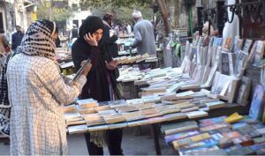 Woman busy in selecting and purchasing old books from roadside setup in Provincial Capital