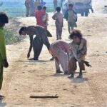 Gypsy children enjoy playing (Gilli danda) game at tando yousuf