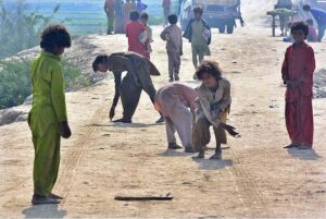 Gypsy children enjoy playing (Gilli danda) game at tando yousuf