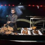A vendor is preparing Fish for customers at old bus Stand Road.