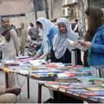 Woman busy in selecting and purchasing old books from roadside setup in Provincial Capital