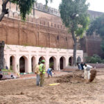 Labourers busy in restoration work on the wall of historical Shahi Qila