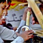 Young vendor busy peeling sugarcane for making juice at roadside near Fruit Market in the Federal Capital
