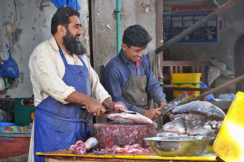 A vendor selling and cutting fish as its demand increased despite high prices of white meat for winter at the Fish Market