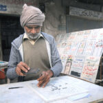 A worker is busy in curving the name on a marble piece at his workplace
