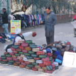A vendor selling and displaying Sindhi hats at his roadside setup