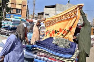 Vendor displaying blanket to attract the customer at station road