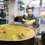 A roadside vendor displaying the chicken soup to attract the customer outside railway station