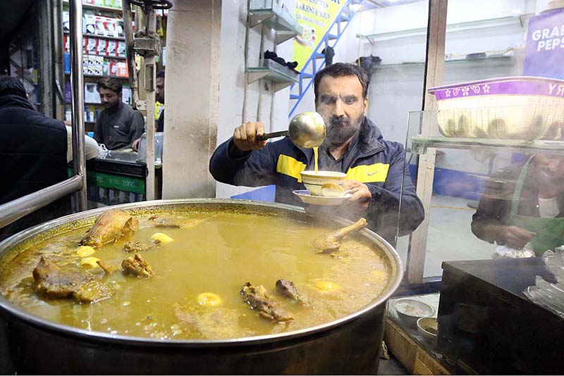 A roadside vendor displaying the chicken soup to attract the customer outside railway station