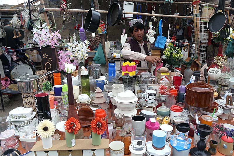 A vendor displaying the crockery items to attract the customer at Makki Shah Road