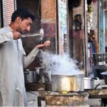 A worker busy in making tea at his hotel near Railway Station Road