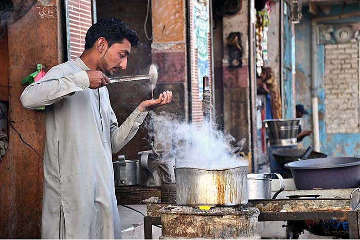 A worker busy in making tea at his hotel near Railway Station Road