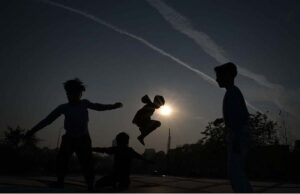 Gypsy children enjoying jump on trampoline during sunset at G-7 area