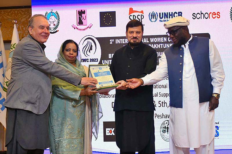 VC SBBWU Prof. Dr. Safia Ahmed, SRSP CEO Masaud ul Mulk and UNHCR KP Head Kofi Ohenenana Dwomo giving shield to Governor KP Haji Ghulam Ali during 1st International Women Conference on Breaking Barriers, Building Bridges, Uniting Women's Voice for a Better World at Local hotel