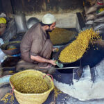 A worker busy in roasting gram at his workplace
