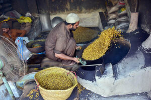 A worker busy in roasting gram at his workplace