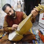Worker busy in making traditional musical instrument (Rabab) at his workplace in the Dabgari area