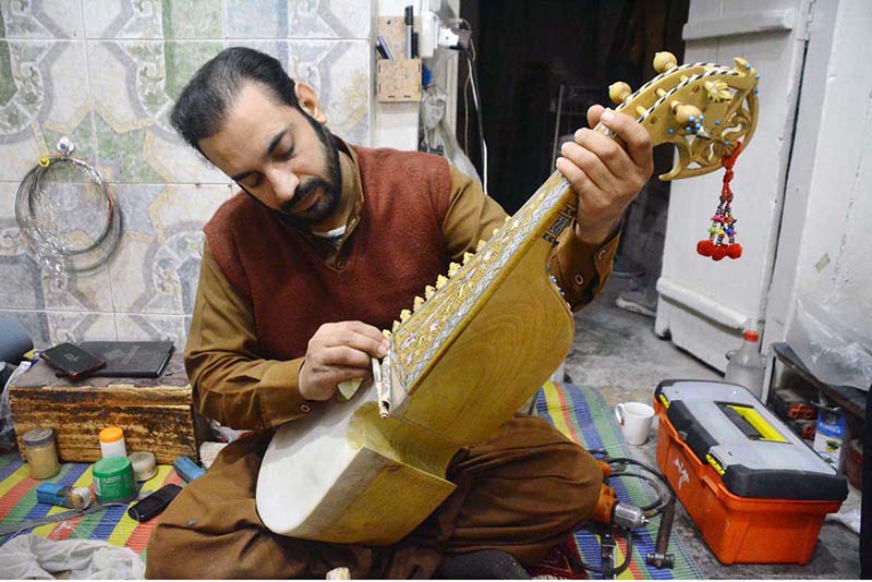 Worker busy in making traditional musical instrument (Rabab) at his workplace in the Dabgari area