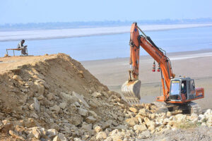 Labourer busy in repairing the embankment of Indus River with the help of machine at Husseinabad