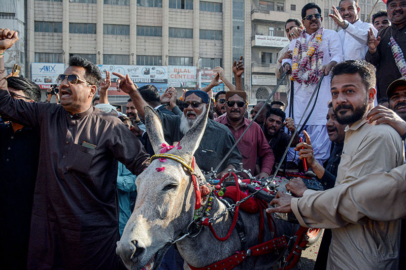 Pakistan People's Party (PPP) General Secretary Karachi Javed Nagori with his supporters riding on donkey cart to submit nomination paper of PS-106 for the upcoming General Election 2024 at Deputy Commissioner South office