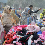 People selecting and purchasing secondhand warm clothes at Landa Bazaar