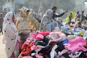 People selecting and purchasing secondhand warm clothes at Landa Bazaar
