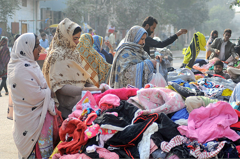 People selecting and purchasing secondhand warm clothes at Landa Bazaar