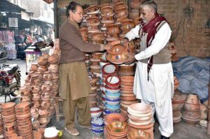 A person busy in selecting handmade clay pots at Qainchi stop