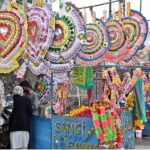 A vendor displaying the flowers and money garlands for wedding and other functions to attract the customers at roadside setup