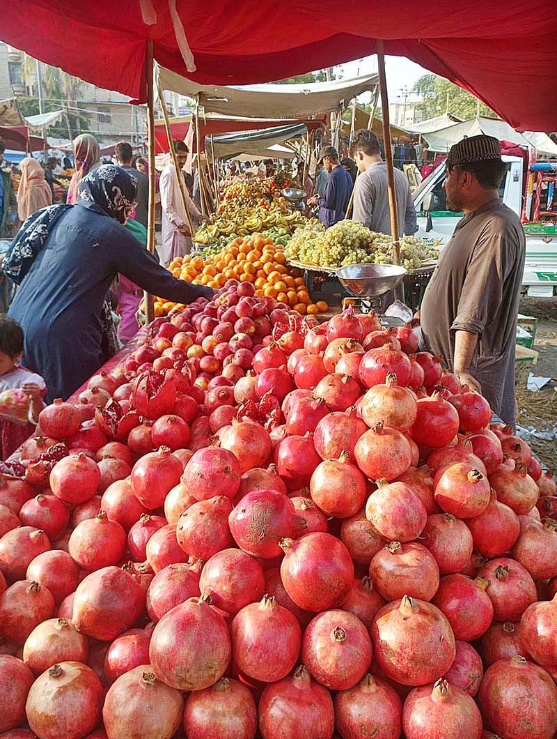 A vendor displaying seasonal fruits at his roadside setup to attract the customers