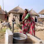 A villager lady filling water from a hand pump at the model of the Climate Resilience Markaz of bamboo housing by the Intellectual Property Organization, Government of Pakistan, in Pono village