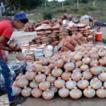 A vendor busy in arranging and displaying clay Golak (money boxes) to attract the customers at his roadside setup in Provincial Capital.