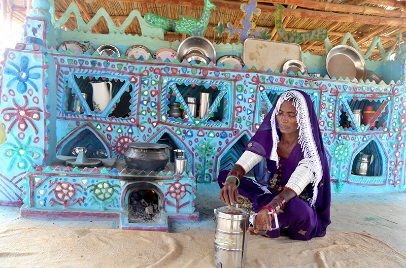 A villager lady filling water from a hand pump at the model of the Climate Resilience Markaz of bamboo housing by the Intellectual Property Organization, Government of Pakistan, in Pono village