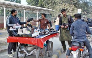 Customers purchasing shoes from roadside stall
