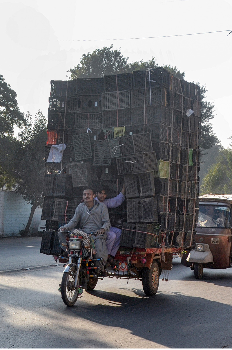 A tricycle rickshaw overloaded with plastic crates at LMQ Road which may cause any mishap and need attention of the authorities