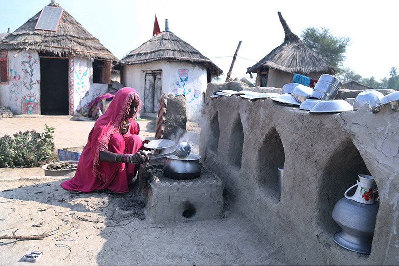 A villager lady filling water from a hand pump at the model of the Climate Resilience Markaz of bamboo housing by the Intellectual Property Organization, Government of Pakistan, in Pono village