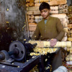 A carpenter busy in making part of a traditional bed (charpai) at his workplace in Dabgari area.