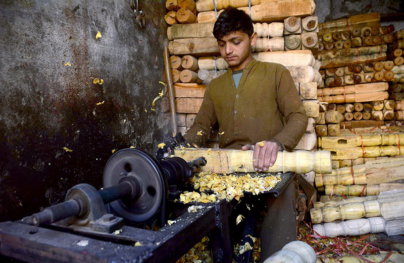 A carpenter busy in making part of a traditional bed (charpai) at his workplace in Dabgari area.