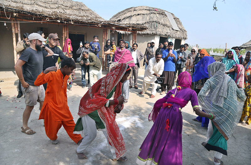 A villager lady filling water from a hand pump at the model of the Climate Resilience Markaz of bamboo housing by the Intellectual Property Organization, Government of Pakistan, in Pono village