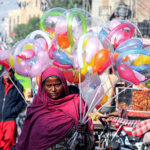 A women vendor displaying balloons to attract the customers at Royal Road.