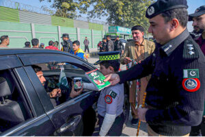 Chief Traffic Police Officer Dr. Zahid Ullah distributing helmets, mugs and history books of Quaid-e-Azam to a motorcyclist on the occasion of Quaid-e-Azam day at Khyber Road.