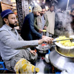 A vendor preparing warm traditional soup for a customer along a street during winter season in the Provincial Capital