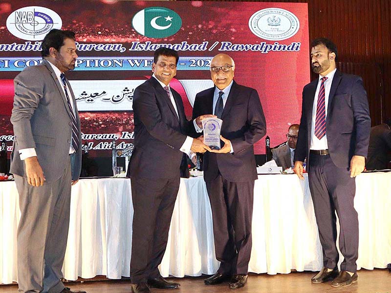 Mirza Irfan Baig, Director General NAB Rwp/Isb, presents a souvenir to Dr. Muhammad Amjad Saqib, Chairperson BISP, at an event organized by the National Accountability Bureau (NAB) and Legal Aid and Justice Authority (LAJA).