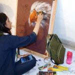 An arts student giving final touch to her painting in painting competition’ at Al Hamra