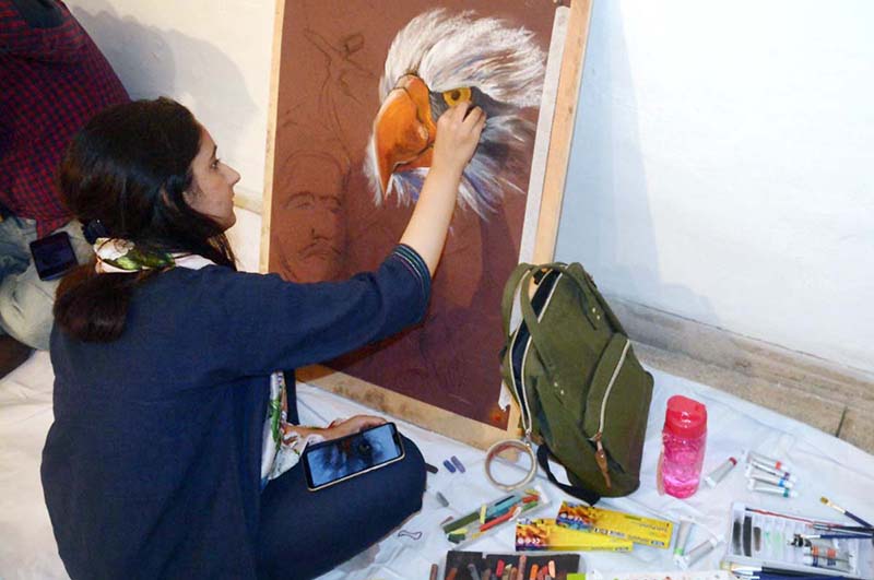 An arts student giving final touch to her painting in painting competition’ at Al Hamra