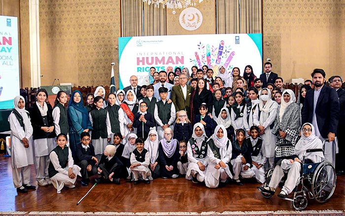 President Dr Arif Alvi in a group photo with children at an event in connection with International Human Rights Day, at Aiwan-e-Sadr.