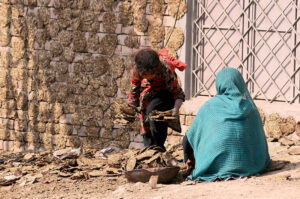 A woman with her daughter collecting dry dung cakes used for burning purpose